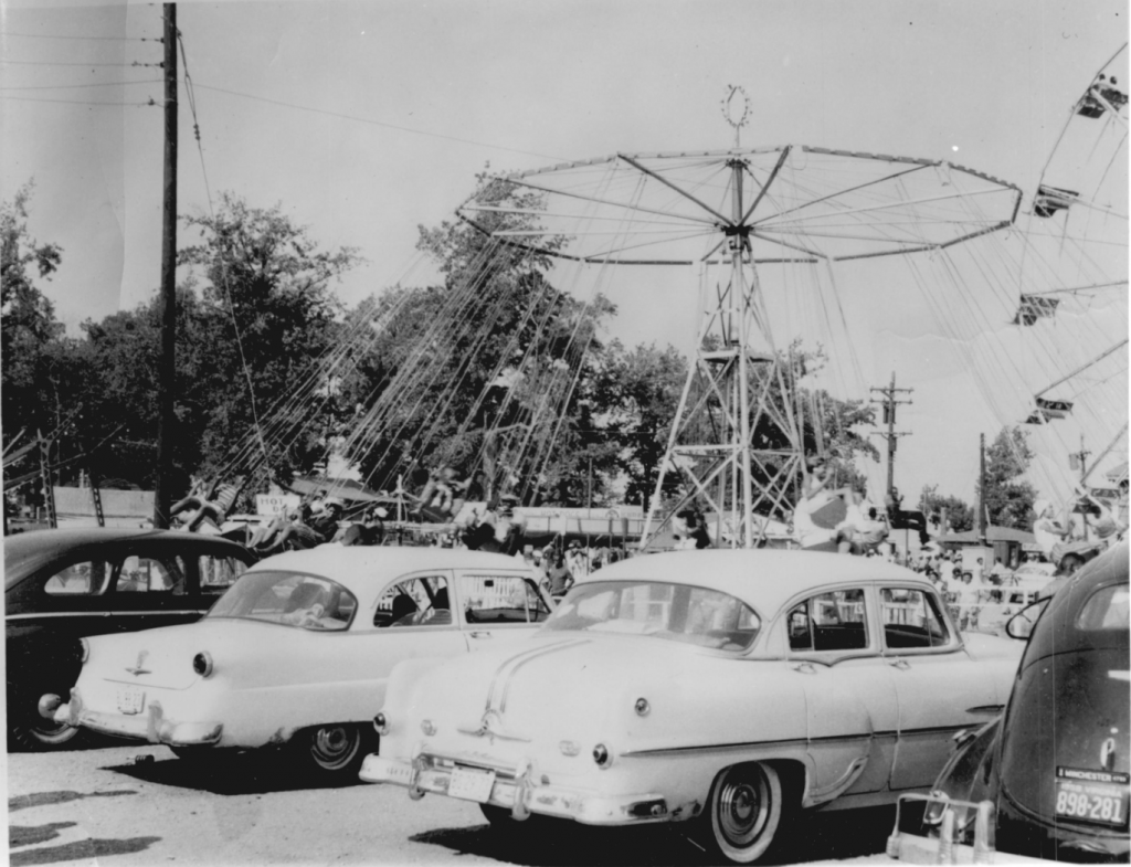 four cars parked in front of swing ride at Carr's Beach amusement park